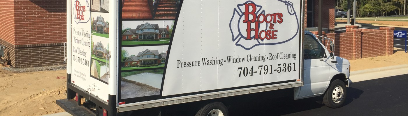 Boots and Hose Pressure Washing truck parked outside of a brick building.